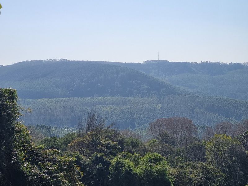 A scenic, elevated view overlooking a vast expanse of lush, forested hills and natural landscape.