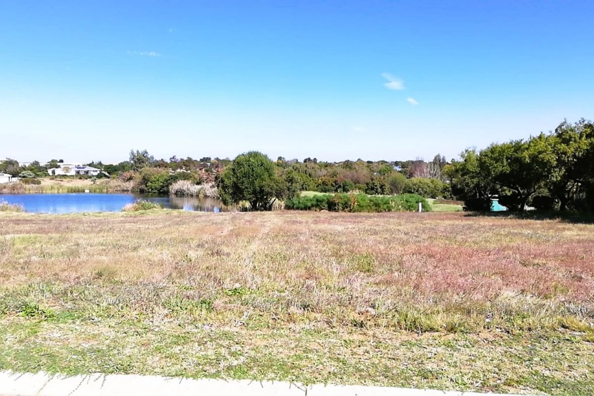 A vacant residential plot offering scenic views of the adjacent lake and surrounding natural landscape.