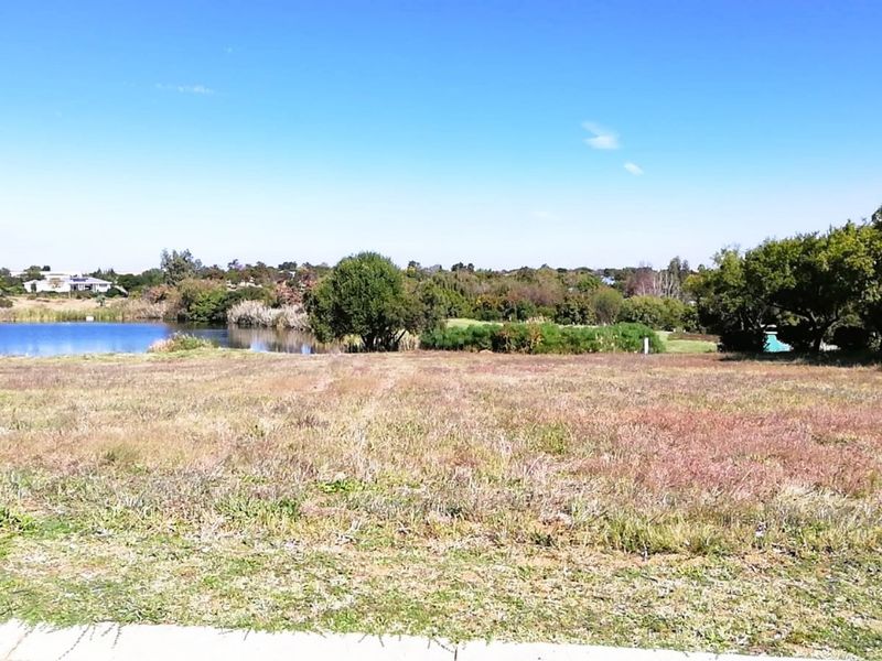 A vacant residential plot offering scenic views of the adjacent lake and surrounding natural landscape.