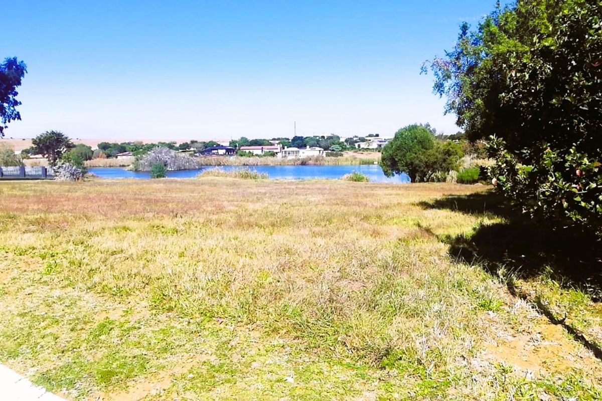 A scenic view of a tranquil lake and surrounding landscape, showcasing the natural beauty and open space of the residential land.