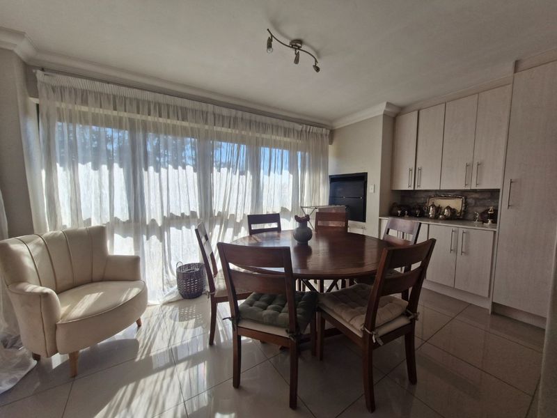 Open plan dining area featuring tiled floors, built-in cabinetry, and a fireplace, with large sliding doors providing ample natural light.