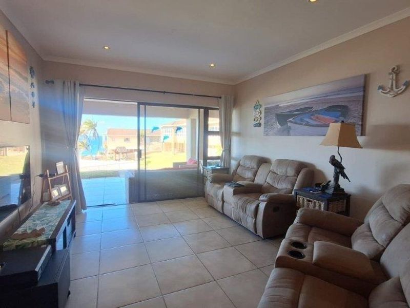 A comfortable living room featuring tiled flooring and a large sliding glass door that provides direct access to an outdoor patio area.