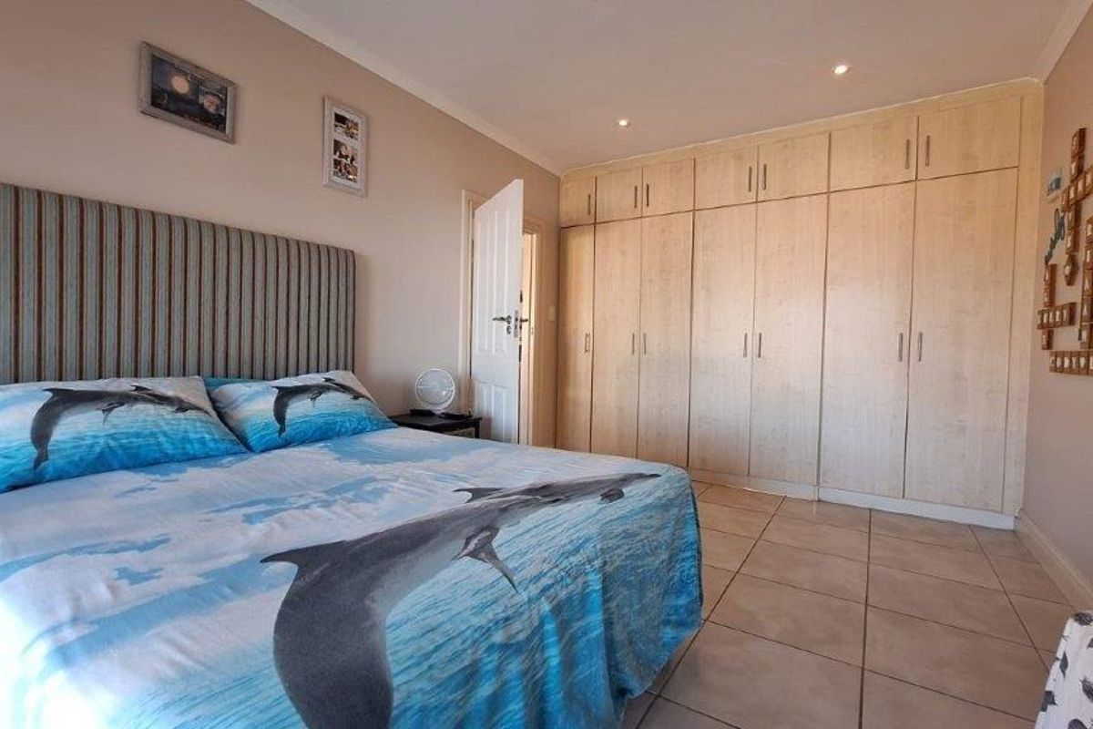 A bedroom featuring tiled flooring, recessed downlighting, and extensive built-in cabinetry providing ample storage space.