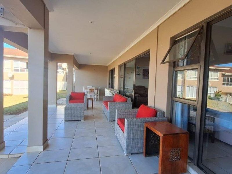 A spacious covered patio featuring tiled flooring and large sliding glass doors, providing seamless access to the interior living spaces.