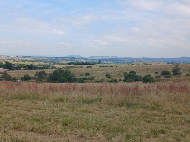 A scenic, expansive view of the surrounding rural landscape and rolling hills, showcasing the natural beauty of the farm property.