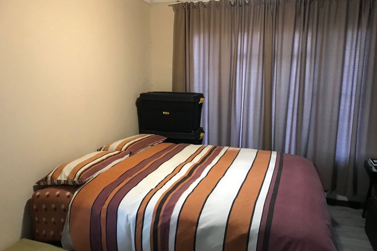 A standard bedroom featuring crown molding and window curtain tracks, providing a neutral base for potential interior updates.