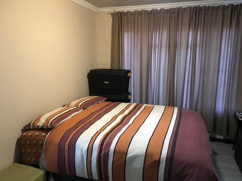 A standard bedroom featuring crown molding and window curtain tracks, providing a neutral base for potential interior updates.