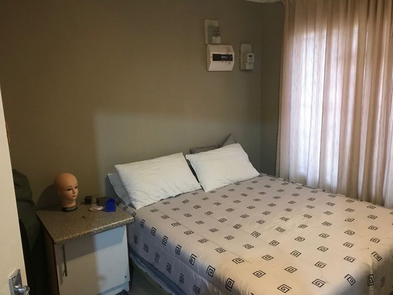 A standard bedroom featuring neutral wall tones and an integrated electrical distribution board, offering a functional space ready for personalization.