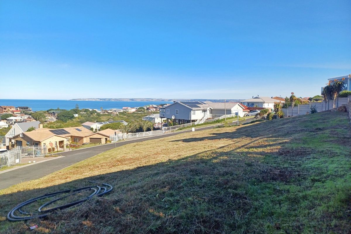 A vacant residential plot featuring a gentle slope and expansive coastal views overlooking the surrounding neighborhood and ocean.