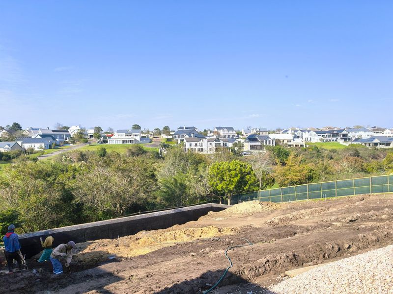 An elevated view overlooking a residential estate with ongoing earthworks and site preparation in the foreground.