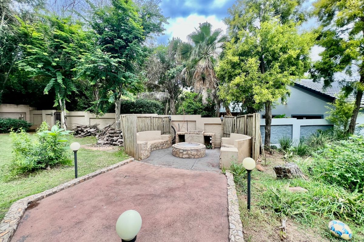 Outdoor entertainment area featuring a built-in stone fire pit and integrated masonry seating, set within a private garden space.