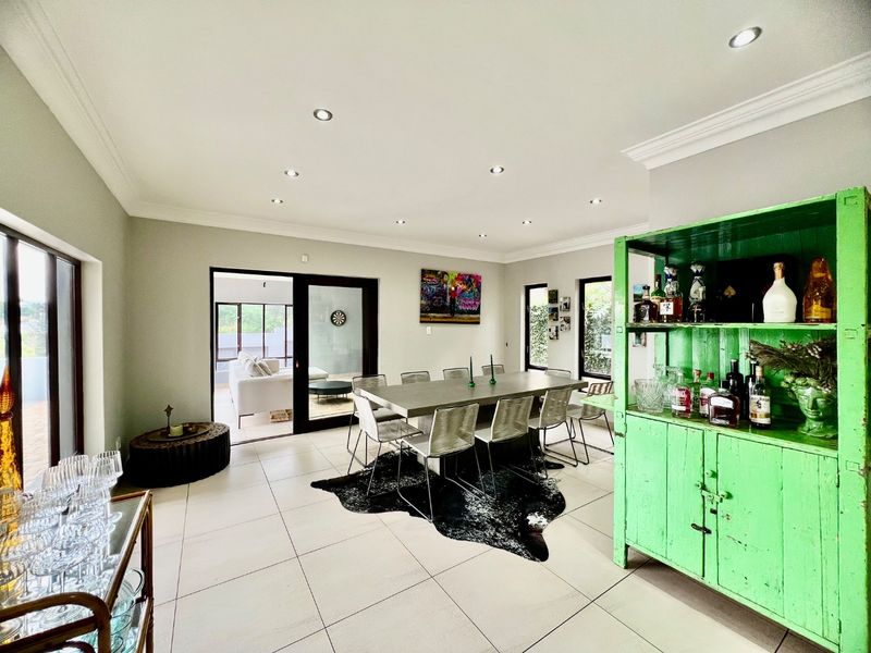 Spacious dining room featuring tiled flooring, recessed downlighting, and large sliding glass doors providing access to the outdoor patio area.