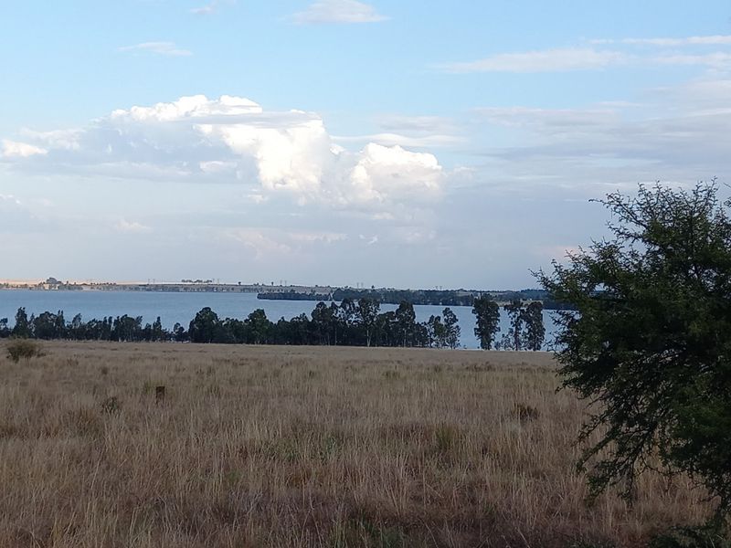 A scenic view of a large water body and natural landscape, showcasing the tranquil surroundings of the vacant residential land.