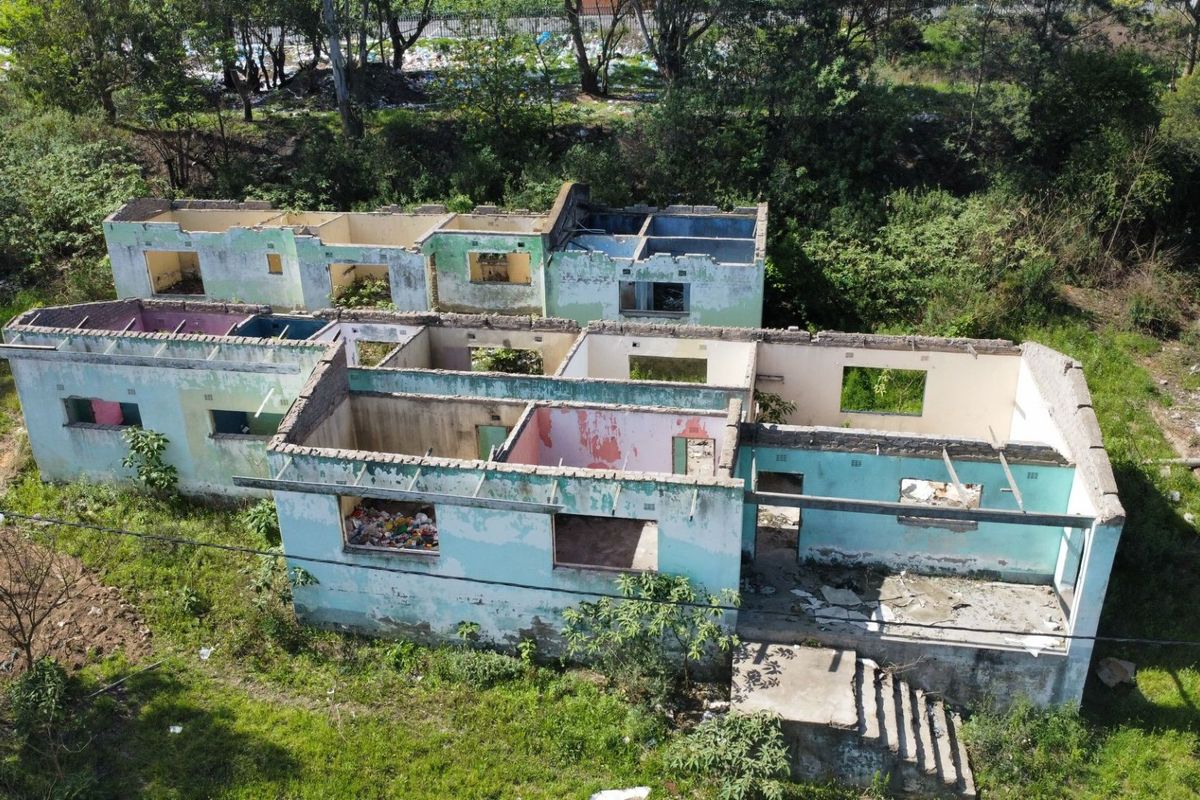 Aerial view of a residential property shell showing masonry walls and concrete foundation with no roof structure present.