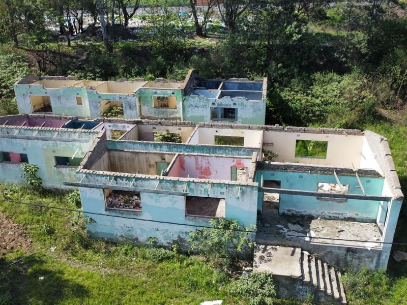 Aerial view of a residential property shell showing masonry walls and concrete foundation with no roof structure present.