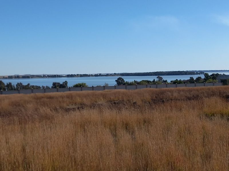 A view of the lake from the vacant residential land, featuring a perimeter boundary wall.