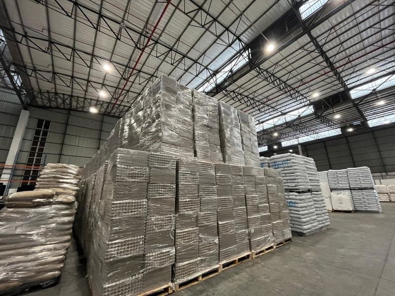 Spacious industrial warehouse facility featuring high ceilings with exposed steel trusses, durable concrete flooring, and integrated overhead lighting.