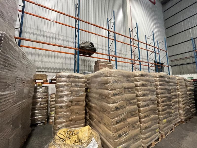 Industrial warehouse space featuring high-level steel racking systems and durable corrugated metal wall cladding, suitable for bulk storage and logistics operations.