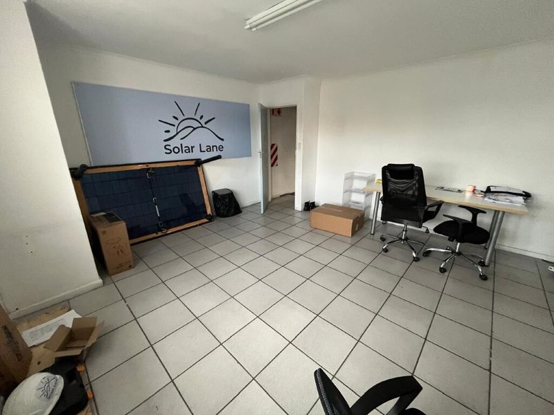 A functional office space featuring ceramic tiled flooring and standard overhead lighting, suitable for administrative or commercial use.