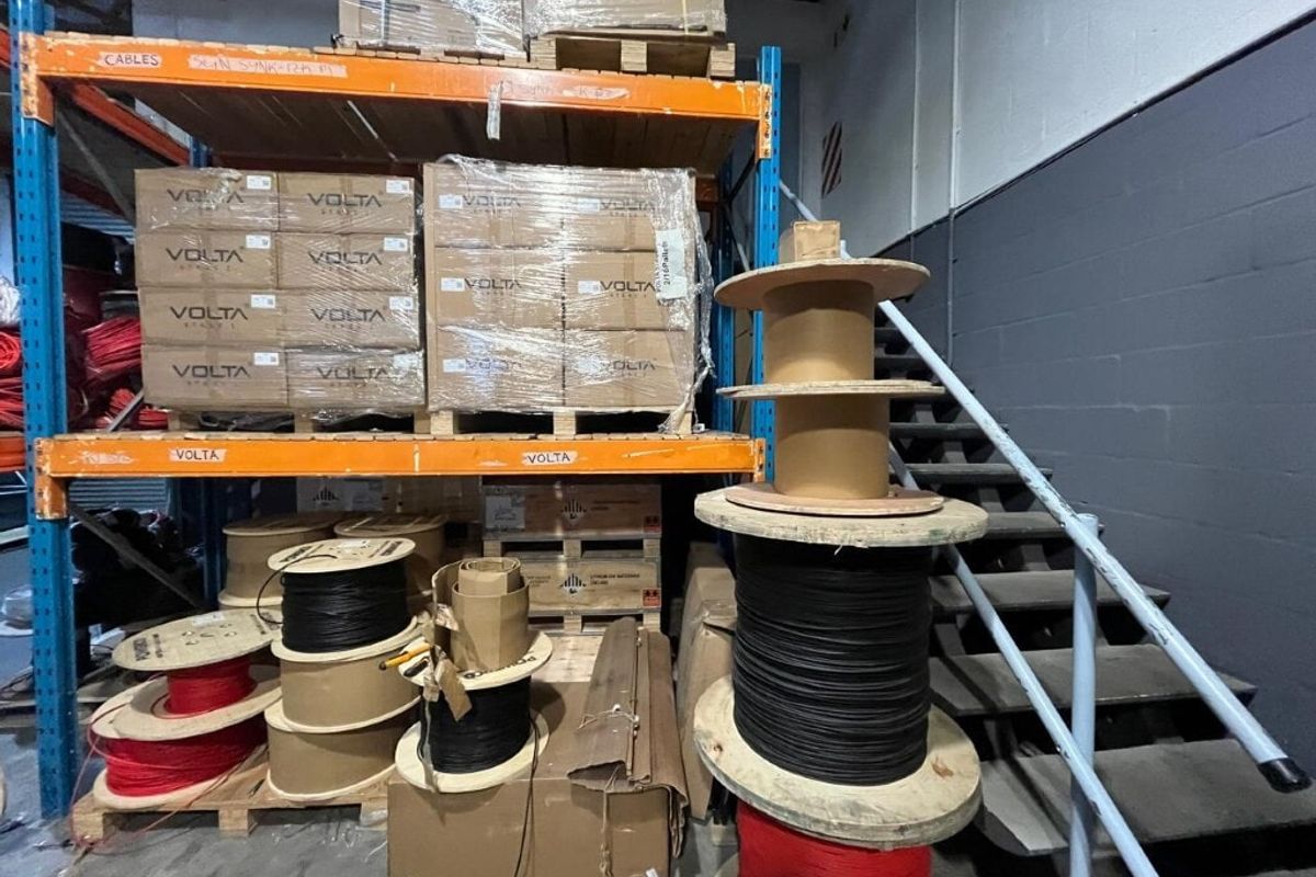 Industrial warehouse utility space featuring heavy-duty steel racking systems for storage and a metal staircase providing access to upper levels.