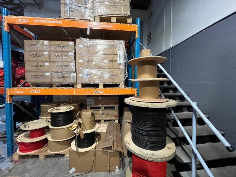 Industrial warehouse utility space featuring heavy-duty steel racking systems for storage and a metal staircase providing access to upper levels.
