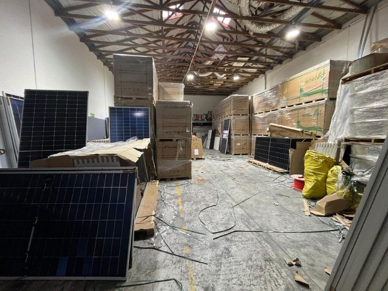 Spacious industrial utility area featuring exposed timber roof trusses, concrete flooring, and functional overhead lighting, suitable for storage or workshop use.