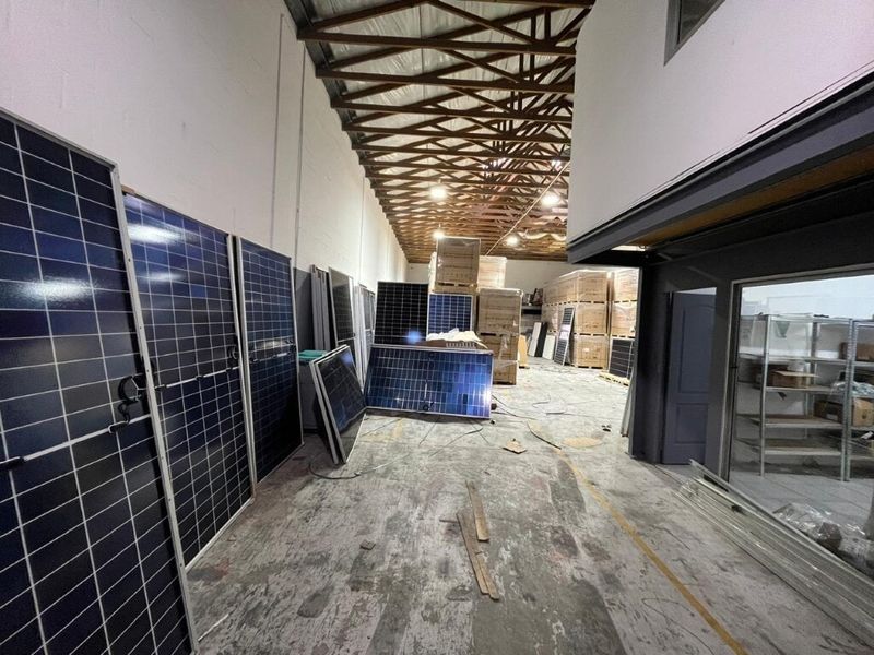 Spacious industrial utility area featuring exposed timber roof trusses, concrete flooring, and high ceilings, suitable for storage or workshop operations.