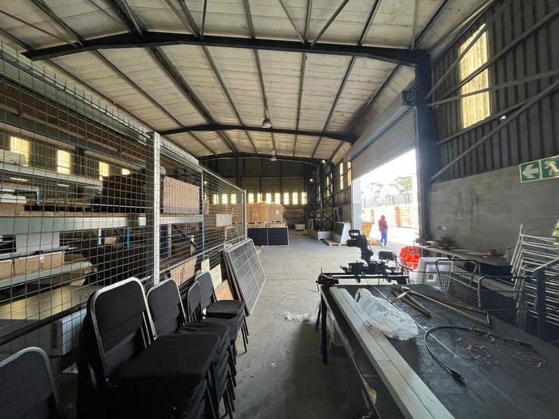 Spacious industrial warehouse unit featuring high-clearance steel portal frame construction, concrete flooring, and large roller shutter access for efficient loading and storage operations.