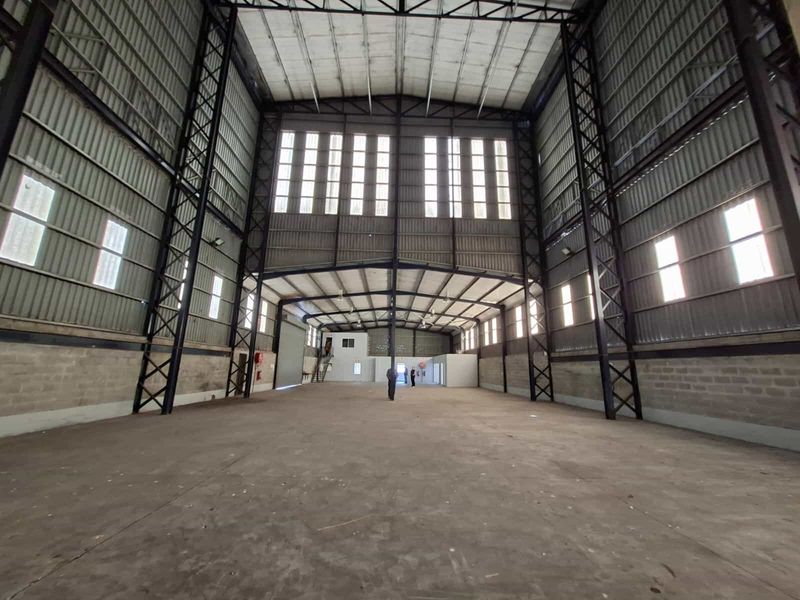 Spacious industrial warehouse featuring a high-clearance steel portal frame, concrete flooring, and abundant natural light through large clerestory windows.
