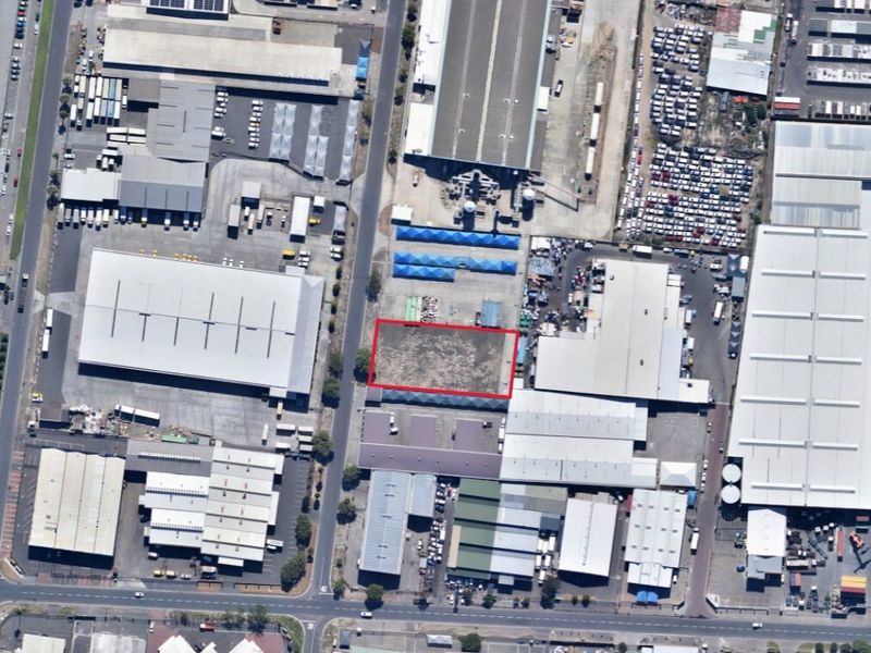 Aerial view of an industrial land parcel situated within a developed industrial park, highlighting the vacant site and surrounding warehouse infrastructure.