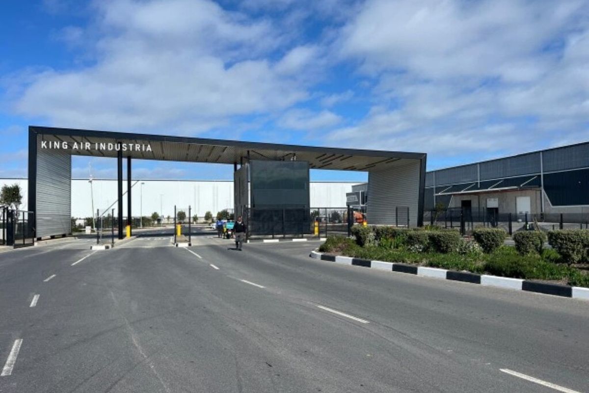 The main entrance and security gatehouse for King Air Industria, featuring modern architectural design, paved access roads, and professional landscaping.