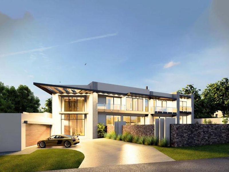 A modern two-story residential property featuring stone cladding, expansive glass windows, balcony railings, and a paved driveway with an integrated garage.