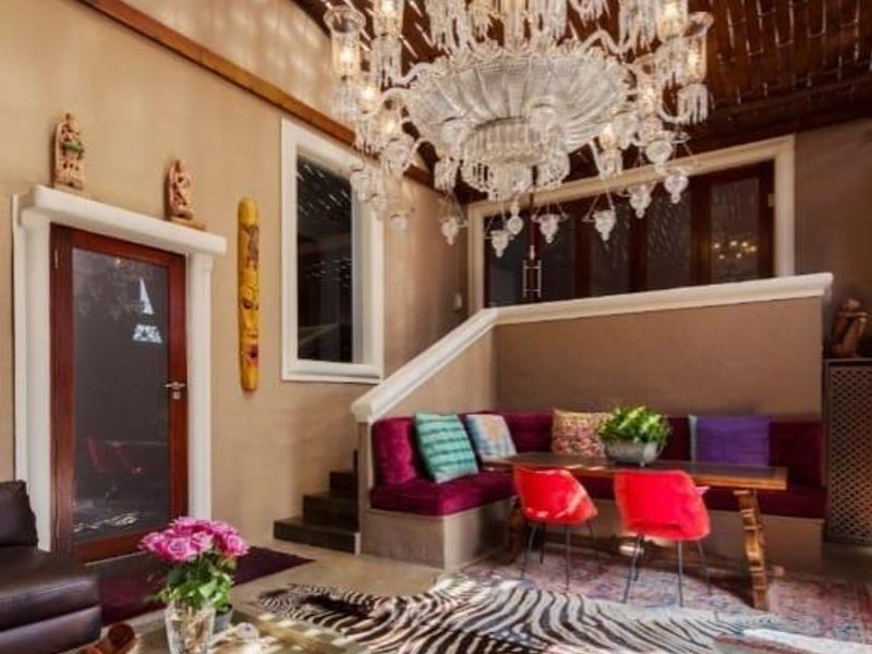 A cozy living area featuring a built-in bench, an ornate chandelier, and a unique exposed timber ceiling, creating a warm and inviting atmosphere.