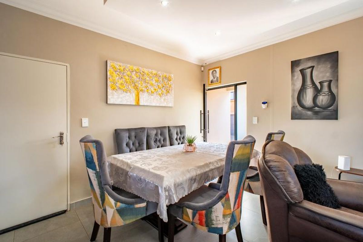 A well-maintained living area featuring neutral wall tones, tiled flooring, and recessed downlighting, providing a comfortable and functional space for daily living.