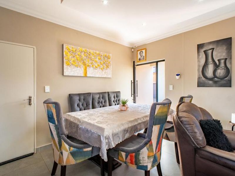 A well-maintained living area featuring neutral wall tones, tiled flooring, and recessed downlighting, providing a comfortable and functional space for daily living.