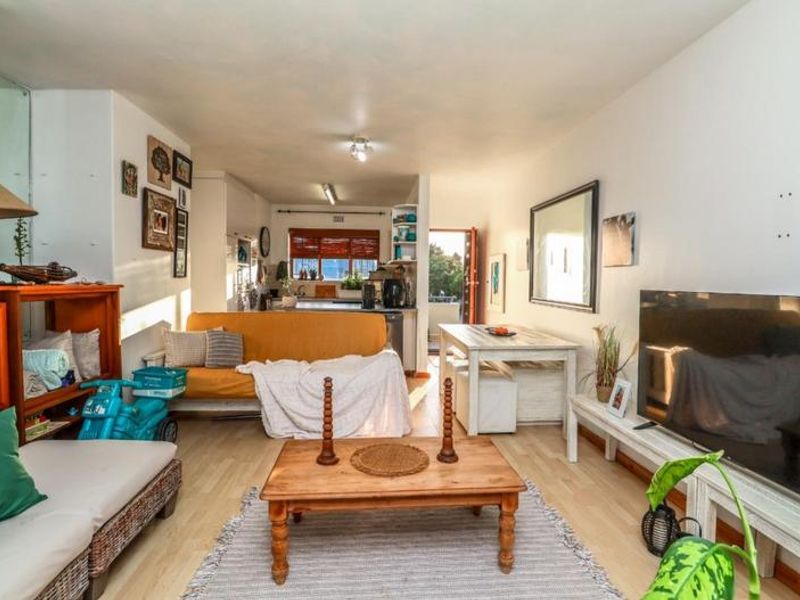 Open plan living and kitchen area featuring laminate flooring and direct access to an outdoor balcony space.