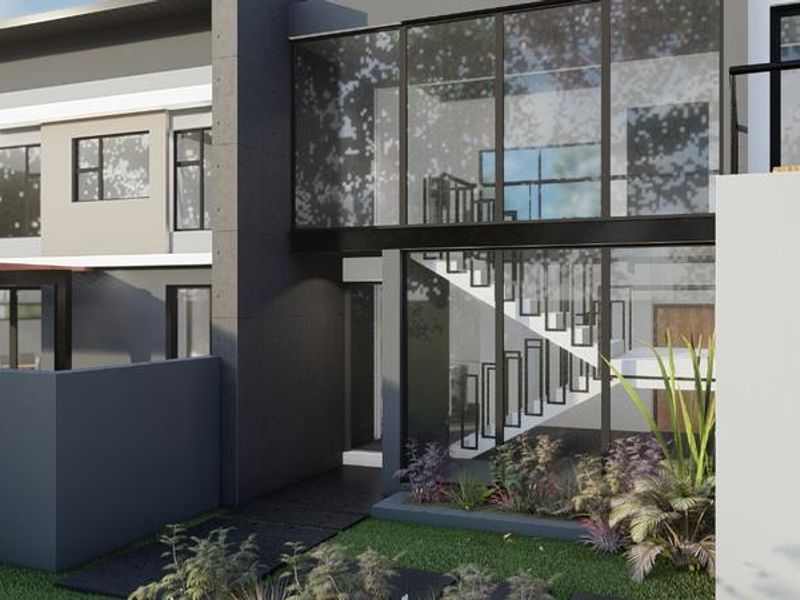 A modern architectural exterior featuring a striking glass facade, steel staircase, and clean contemporary lines with a landscaped front garden.