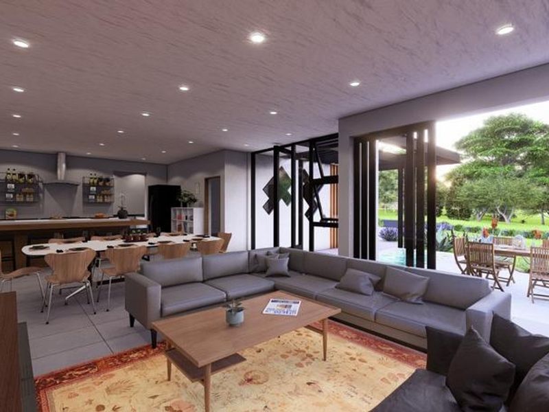 Spacious open-plan living and kitchen area featuring modern finishes, recessed lighting, and seamless indoor-outdoor flow through large sliding glass doors to the patio.