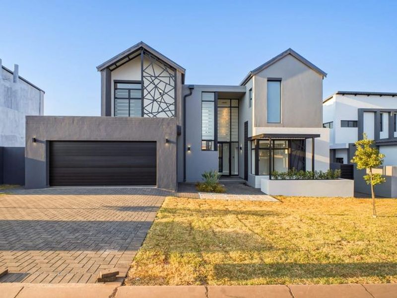 Modern double-story residential home featuring a contemporary facade, paved driveway, double garage, and clean architectural lines.