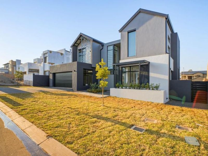Modern double-story residential property featuring a contemporary facade, paved driveway, and integrated double garage with clean architectural lines.