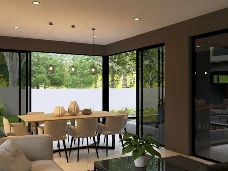 Modern open-plan living and dining area featuring large sliding glass doors that provide seamless access to the garden and abundant natural light.