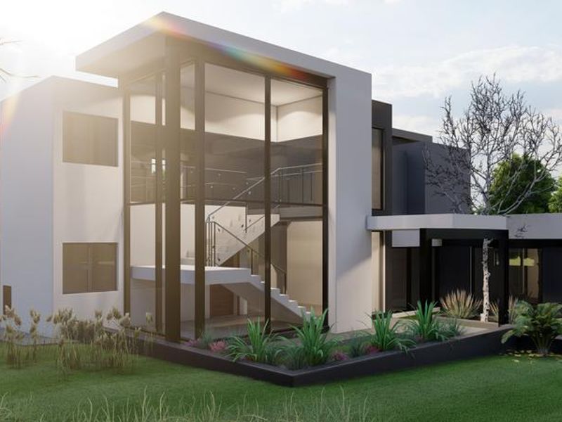 A modern architectural house exterior featuring a striking floor-to-ceiling glass facade, clean geometric lines, and a well-maintained landscaped garden.