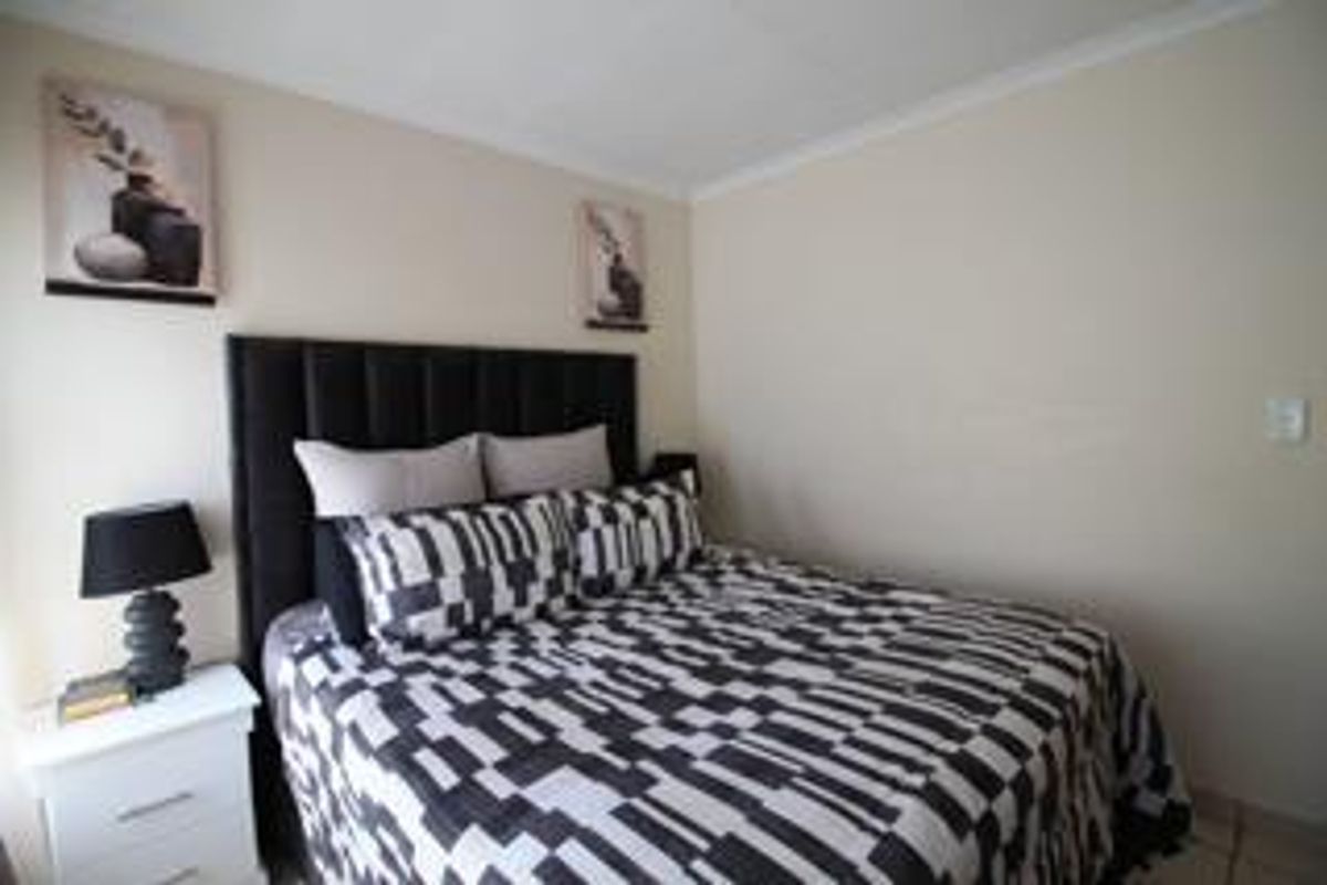 A neutrally painted bedroom featuring coving and a standard layout, providing a clean and functional space for rest.