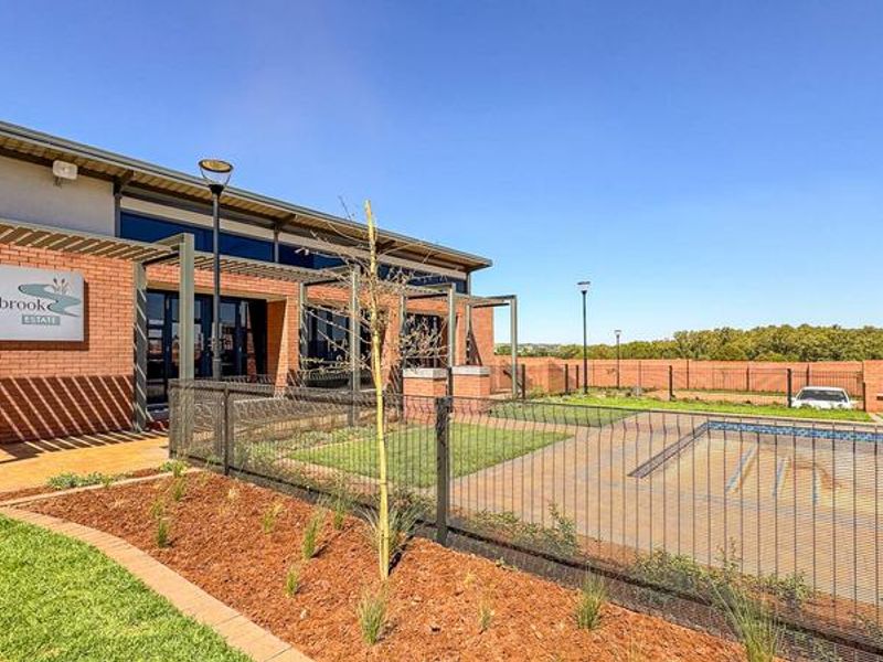 Exterior view of the Fountainbrook Estate clubhouse featuring a modern brick facade, swimming pool area, and landscaped grounds.