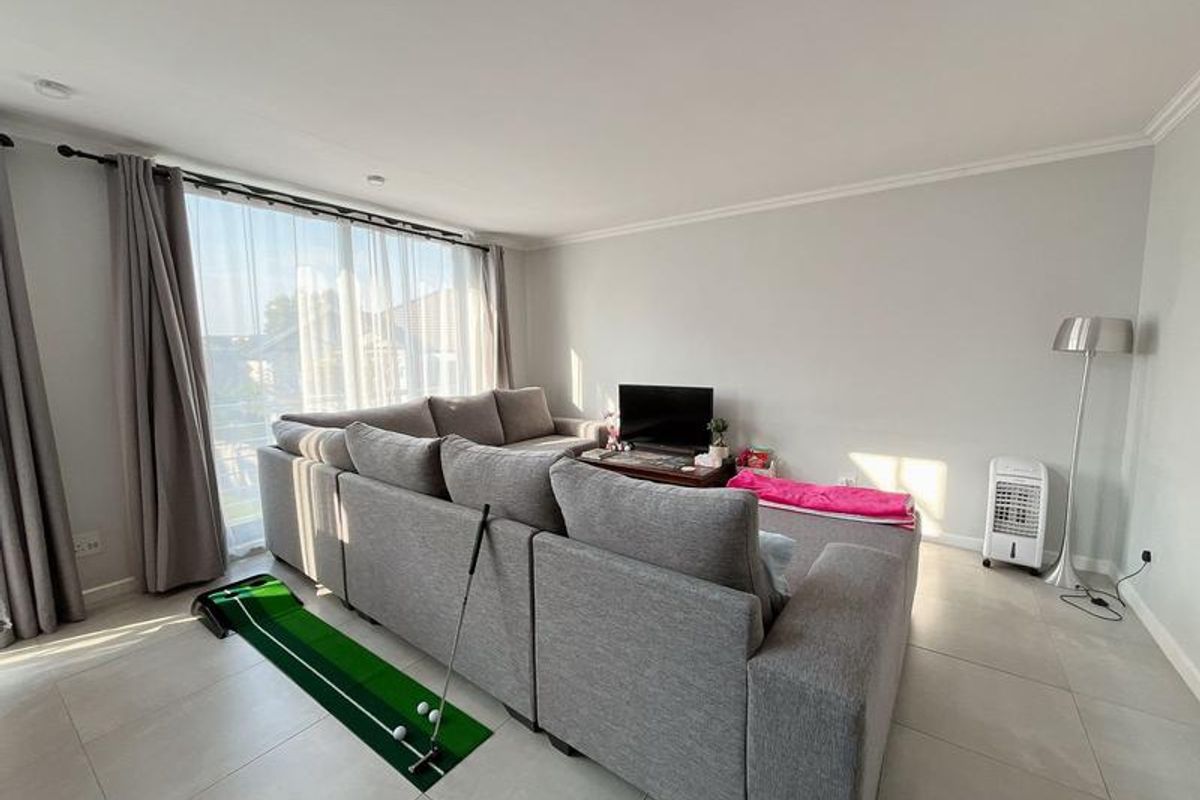A bright and spacious living room featuring large sliding glass doors that provide ample natural light and access to the outdoors.