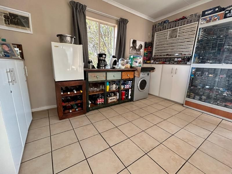 A functional laundry area featuring tiled flooring, built-in cabinetry, and a window, providing practical utility space within the townhouse.