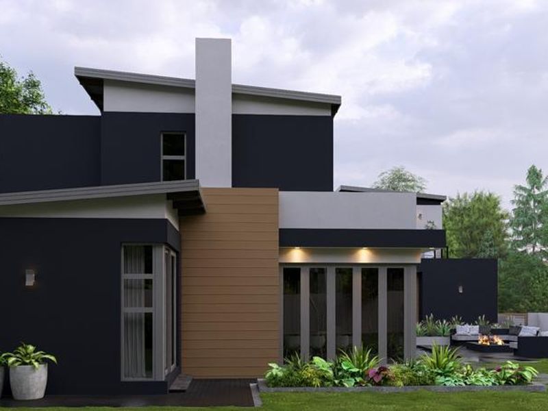 Modern rear elevation featuring a striking dark facade, wood-look cladding, chimney stack, and large bi-fold doors opening onto a landscaped garden area.