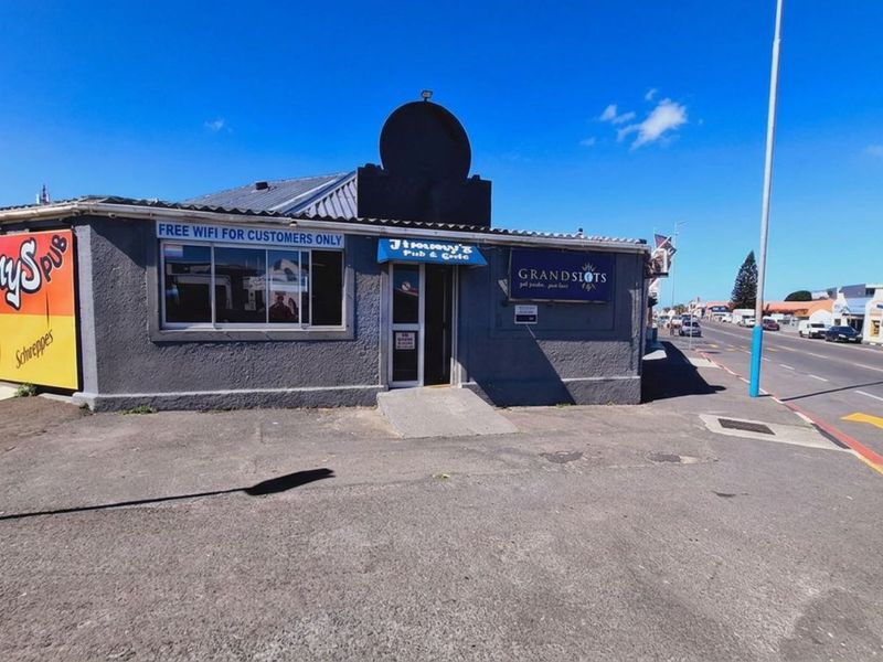 Front exterior view of a commercial pub and grill building featuring signage, a concrete entrance ramp, and adjacent street access.