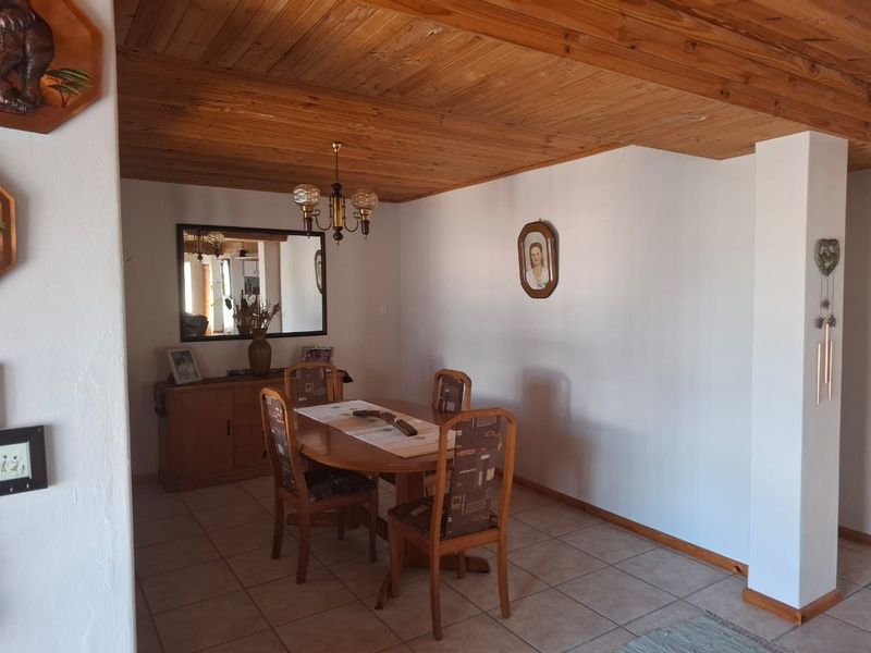 Dining room featuring a warm timber plank ceiling and neutral ceramic floor tiles, providing a classic foundation for a comfortable family dining space.