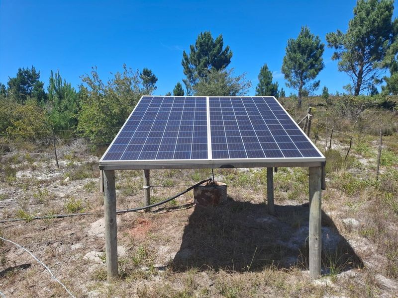 Ground-mounted solar panel array installed on a timber frame, providing renewable energy for the property's borehole pump system.